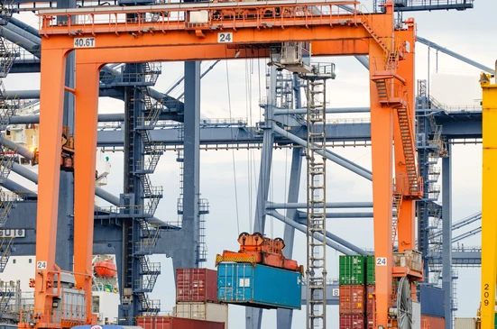 Scène extérieure portuaire avec grues de manutention orange manipulant des conteneurs maritimes colorés